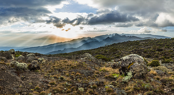 Zon schijnt door de wolken bij Mount Meru